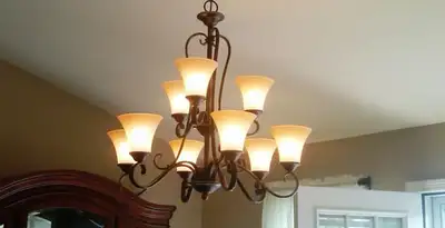Classic ceiling chandelier installation with warm lighting in New Orleans, LA