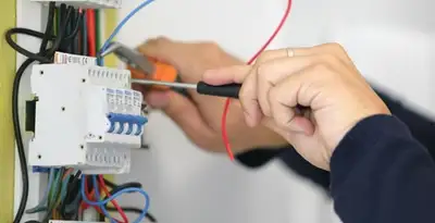 Electrician installing and adjusting circuit breakers in an electrical panel in New Orleans, LA