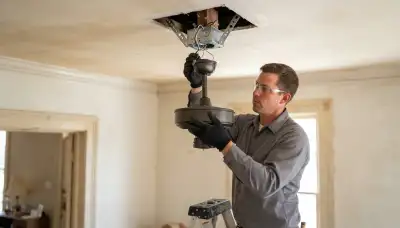 Electrician installs a fan-rated box and mounts a ceiling fan motor in a New Orleans, LA home