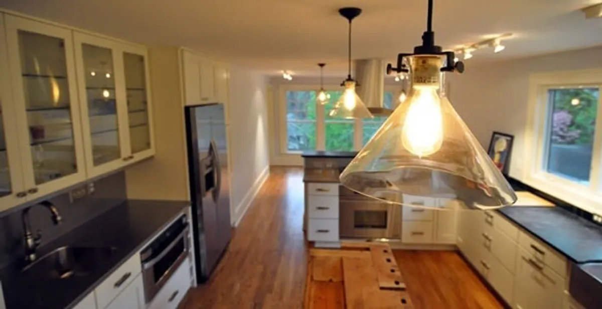 Residential electrician installing modern indoor light fixture in a home in New Orleans, LA