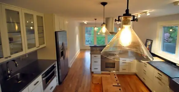 Residential electrician installing modern indoor light fixture in a home in New Orleans, LA