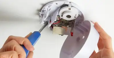 Certified technician wiring smoke detector during installation in New Orleans, LA